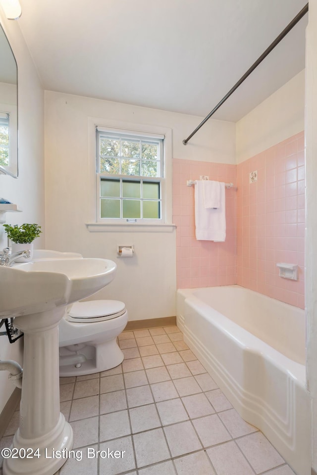 bathroom with tile patterned flooring, tiled shower / bath combo, and toilet