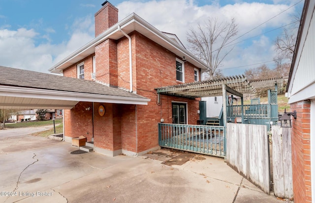 view of side of home featuring a pergola and a carport