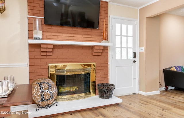 details featuring hardwood / wood-style floors, ornamental molding, and a brick fireplace