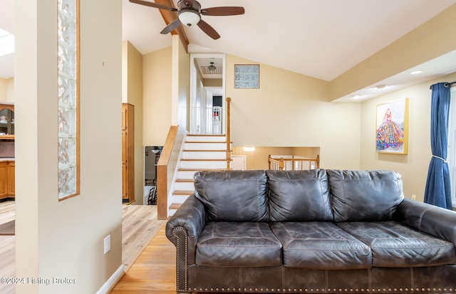 living room featuring ceiling fan, light wood-type flooring, and lofted ceiling