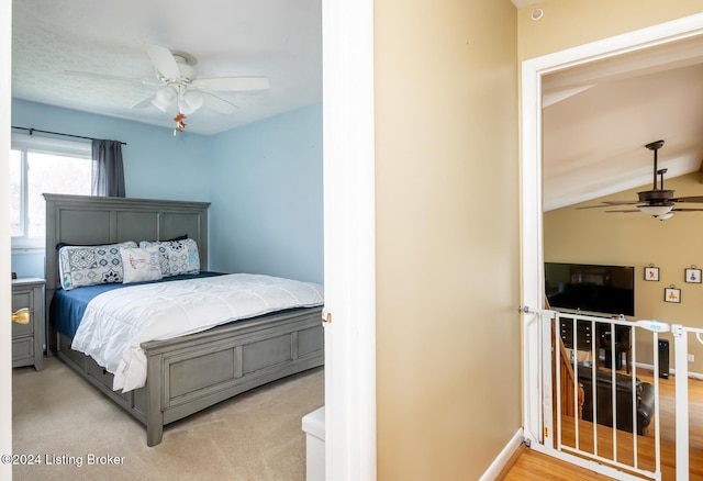 bedroom featuring ceiling fan, light hardwood / wood-style flooring, and vaulted ceiling