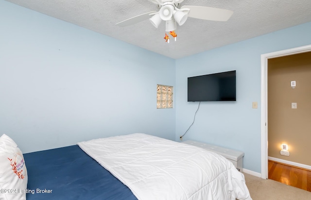 bedroom featuring carpet flooring, ceiling fan, and a textured ceiling