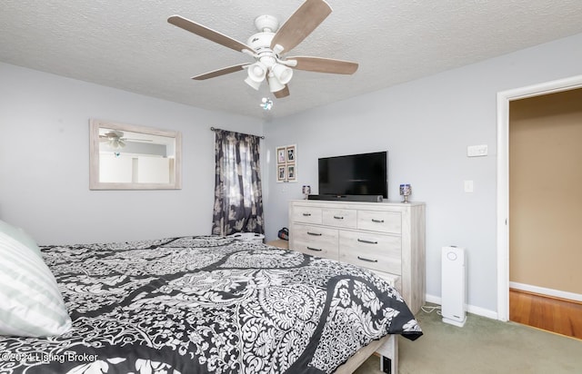 carpeted bedroom with ceiling fan and a textured ceiling