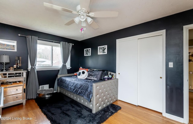 bedroom featuring ceiling fan, a closet, and wood-type flooring