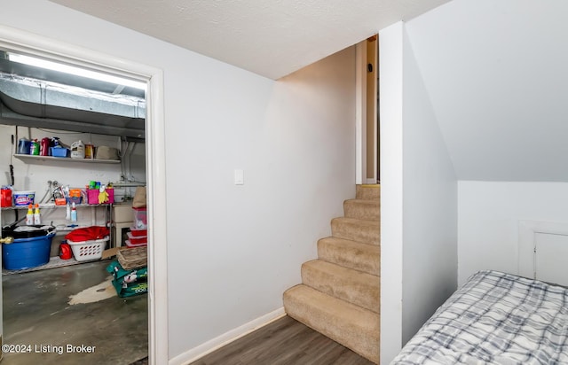 stairway with hardwood / wood-style flooring and a textured ceiling