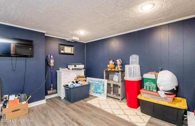 playroom featuring hardwood / wood-style floors, crown molding, and a textured ceiling