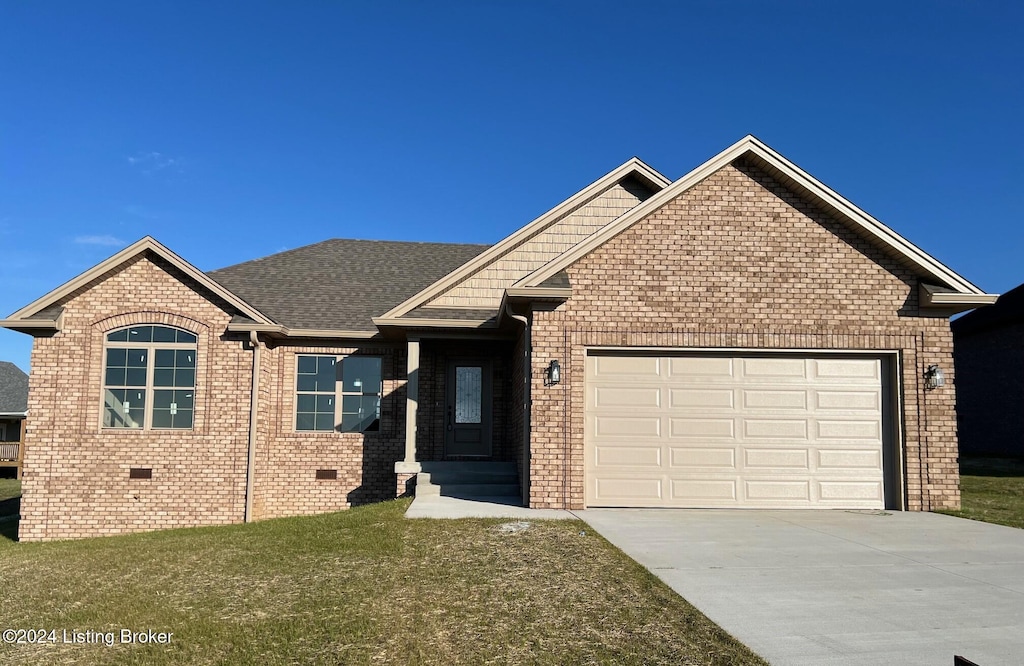 view of front of property with a front yard and a garage