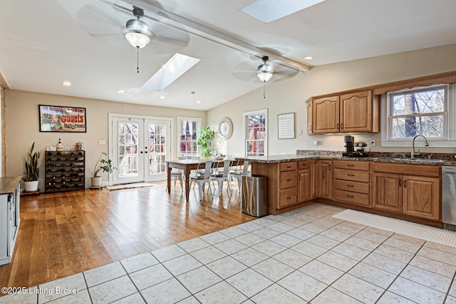 kitchen with sink, light tile patterned floors, french doors, and a healthy amount of sunlight