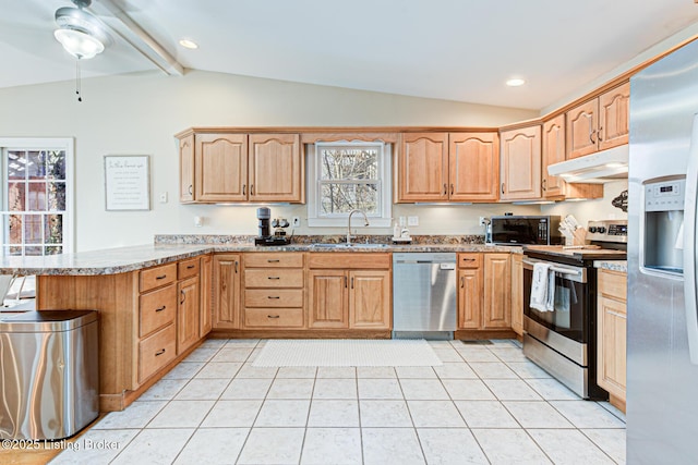 kitchen with sink, light stone counters, lofted ceiling with beams, appliances with stainless steel finishes, and kitchen peninsula