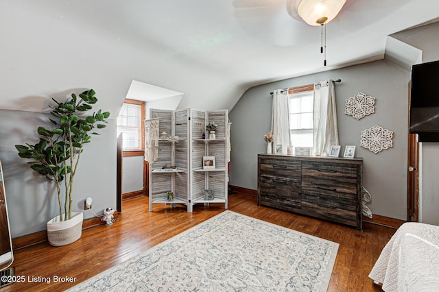 bedroom featuring multiple windows, hardwood / wood-style flooring, vaulted ceiling, and ceiling fan