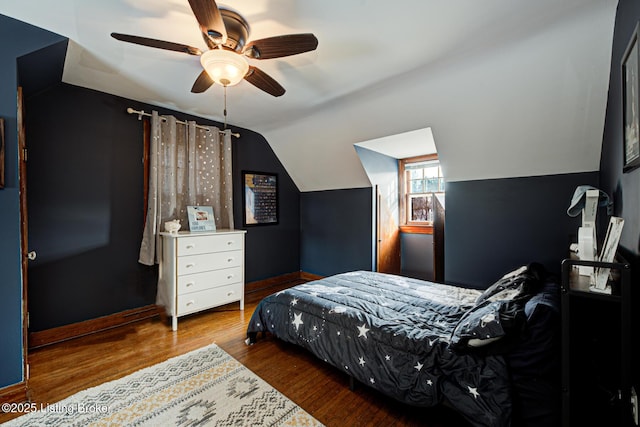 bedroom with vaulted ceiling, wood-type flooring, and ceiling fan