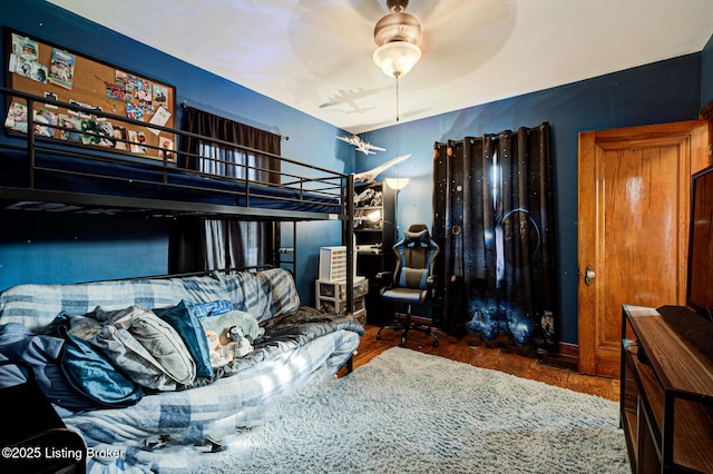 bedroom with dark hardwood / wood-style flooring and ceiling fan