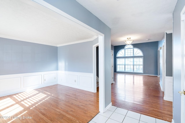 interior space with light tile patterned floors and ornamental molding