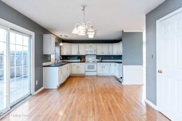 kitchen featuring white appliances, an inviting chandelier, sink, light wood-type flooring, and decorative light fixtures