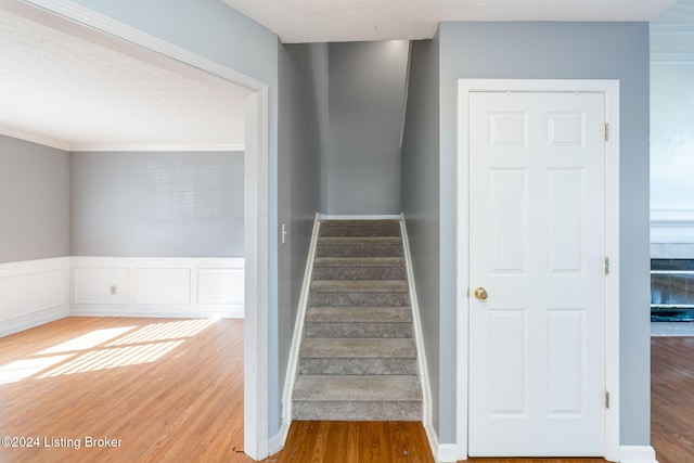 stairway featuring wood-type flooring and a textured ceiling