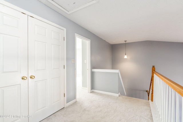 hall featuring light colored carpet and lofted ceiling