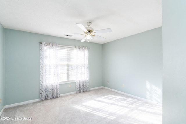 spare room with ceiling fan and light colored carpet