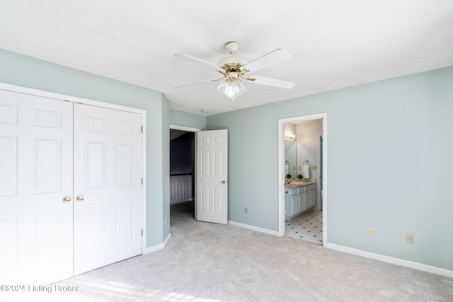 unfurnished bedroom with a closet, ensuite bath, ceiling fan, and light colored carpet