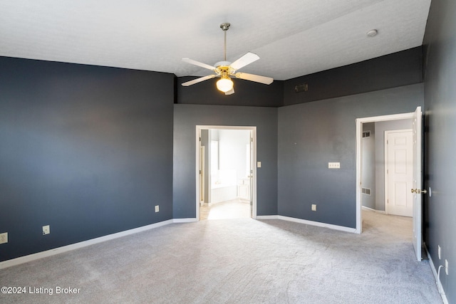 carpeted spare room featuring a textured ceiling and ceiling fan