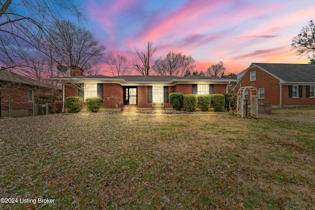 single story home featuring a lawn