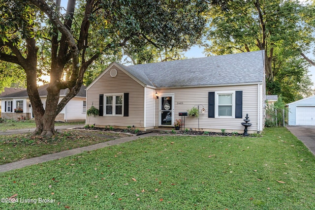 view of front facade featuring an outbuilding, a garage, and a front lawn