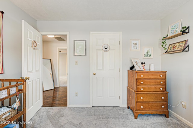 carpeted bedroom featuring a textured ceiling