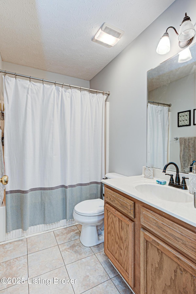 bathroom featuring toilet, tile patterned flooring, a textured ceiling, and vanity