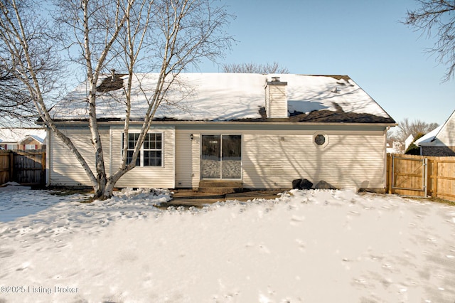 view of snow covered rear of property