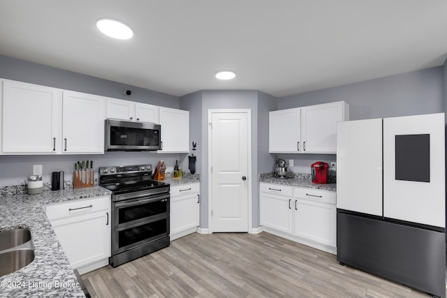 kitchen with white cabinets, sink, light stone countertops, light wood-type flooring, and stainless steel appliances