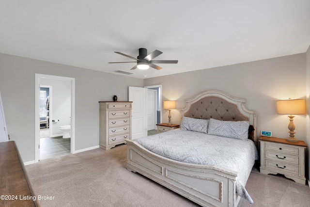 bedroom with connected bathroom, ceiling fan, and light carpet