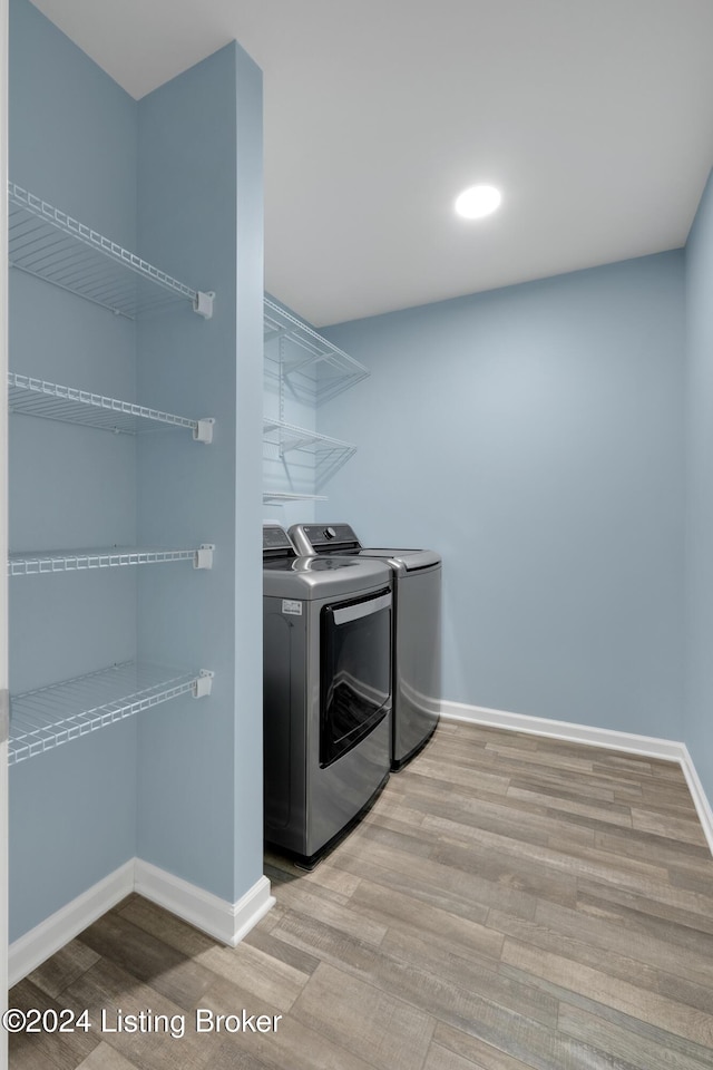 washroom with washer and clothes dryer and light wood-type flooring