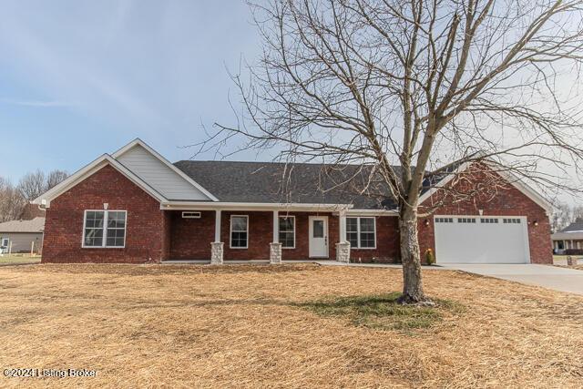 ranch-style home featuring a garage and a front lawn