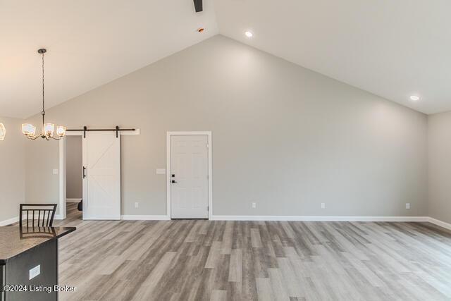 363 S Hamilton Ave, Hanover, IN 47243 - unfurnished living room featuring a barn door, high vaulted ceiling, light wood-style flooring, a chandelier, and recessed lighting
