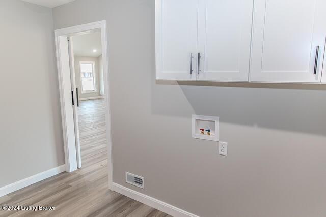 laundry room featuring cabinets, hookup for a washing machine, and light hardwood / wood-style floors