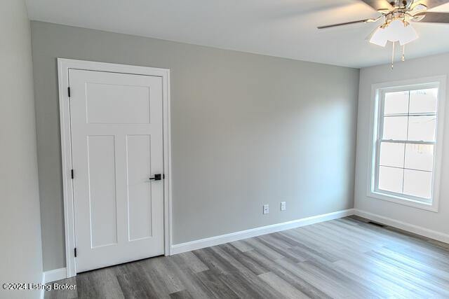 empty room with ceiling fan and hardwood / wood-style flooring