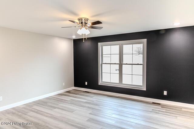 empty room featuring light wood-type flooring and ceiling fan