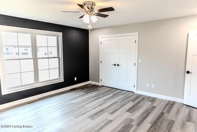 unfurnished bedroom with light wood-type flooring, a closet, and ceiling fan