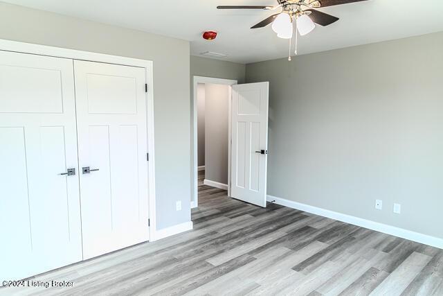 unfurnished bedroom with ceiling fan, light hardwood / wood-style floors, and a closet