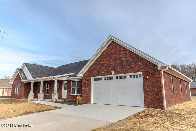 363 S Hamilton Ave, Hanover, IN 47243 - view of front of property with a garage, brick siding, concrete driveway, and covered porch