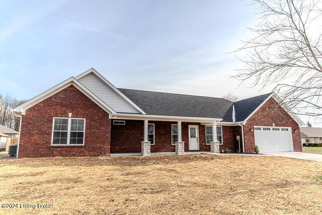 view of front of property featuring a front lawn, cooling unit, and a garage