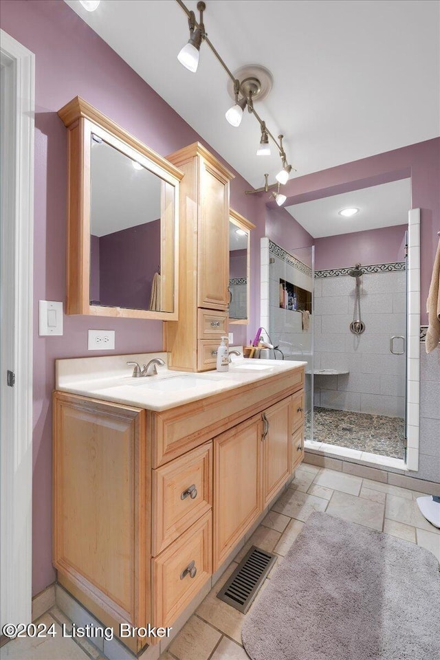 bathroom with a shower with door and vanity