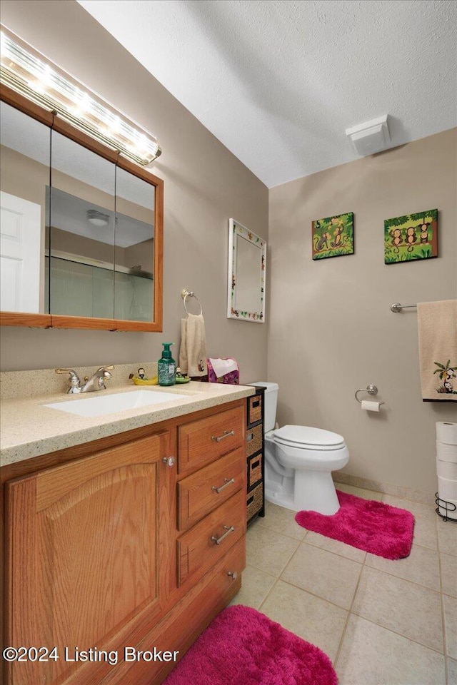 bathroom featuring toilet, a textured ceiling, vanity, and tile patterned floors