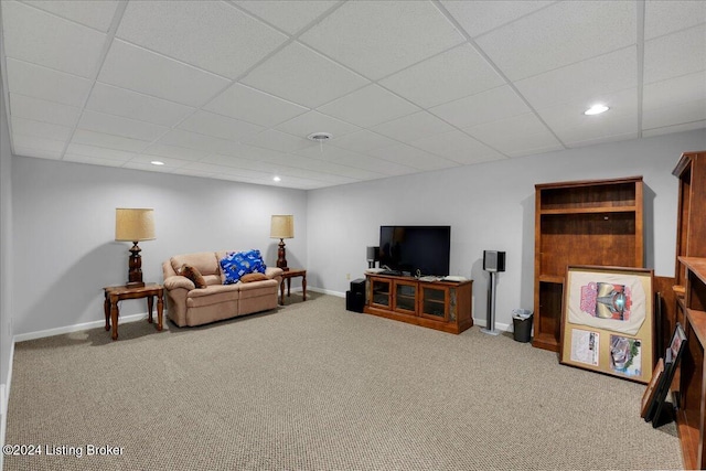 carpeted living room with a paneled ceiling