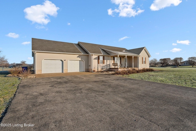 single story home with a porch, a garage, and a front lawn