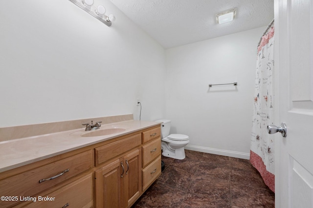 bathroom featuring vanity, toilet, and a textured ceiling