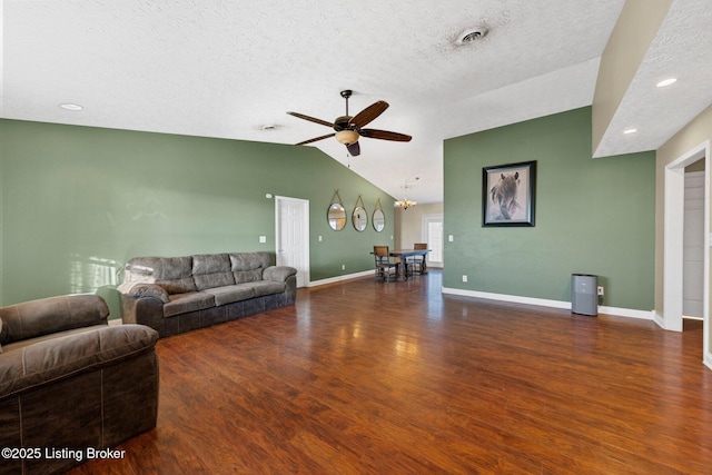 living room featuring a textured ceiling, ceiling fan, dark wood-type flooring, and vaulted ceiling