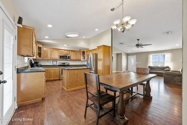 dining space with a textured ceiling, ceiling fan with notable chandelier, dark wood-type flooring, sink, and lofted ceiling