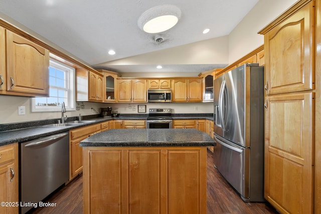 kitchen featuring a center island, sink, dark wood-type flooring, stainless steel appliances, and vaulted ceiling