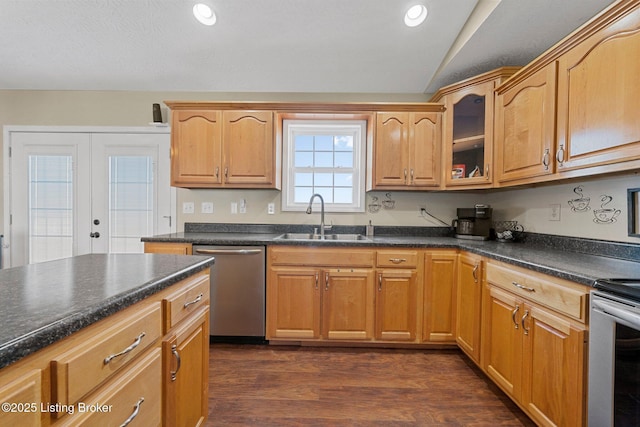 kitchen featuring french doors, stainless steel appliances, vaulted ceiling, dark wood-type flooring, and sink