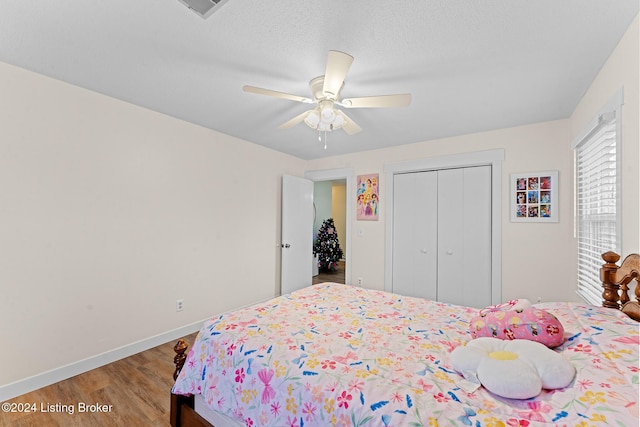 bedroom featuring a textured ceiling, a closet, hardwood / wood-style flooring, and ceiling fan